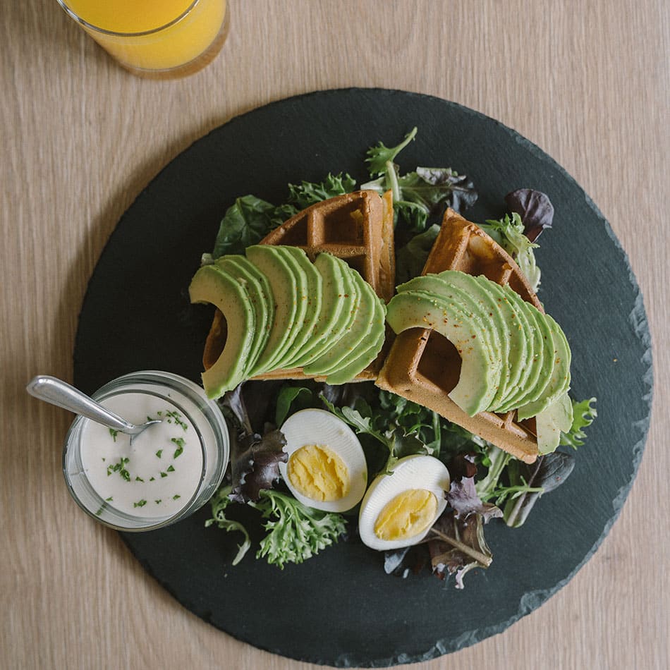 Gaufres croustillantes salées, accompagnées d'avocat, d'œuf et d'une sauce